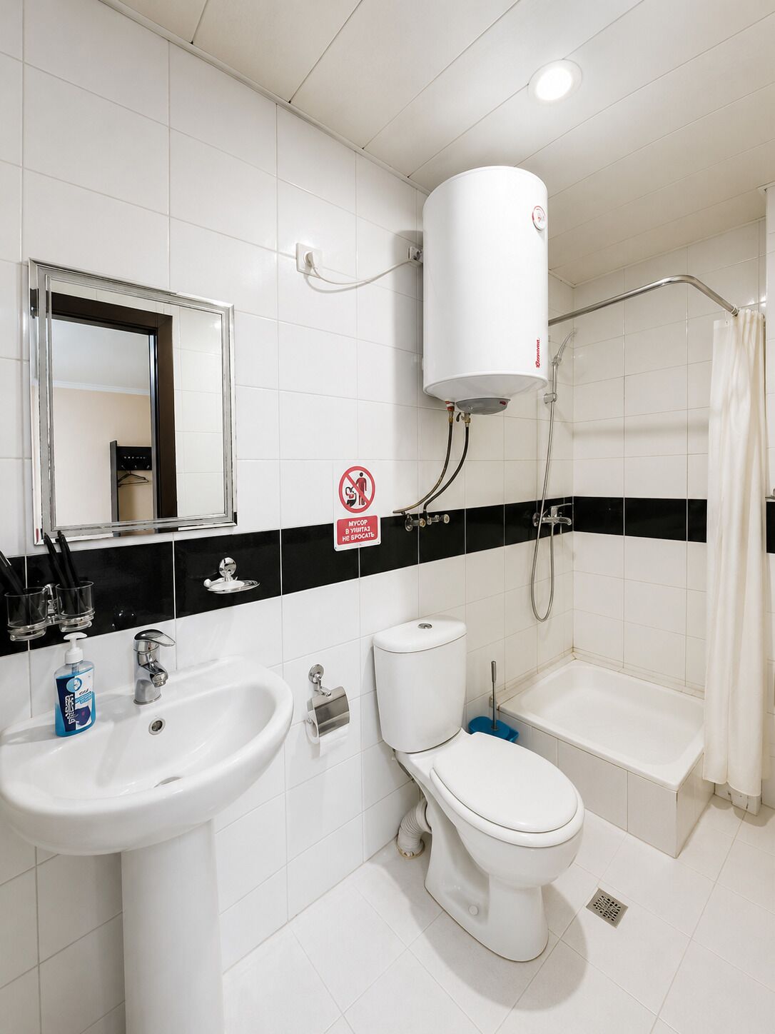 Un baño con lavamanos, inodoro, bañera y cortina de ducha.