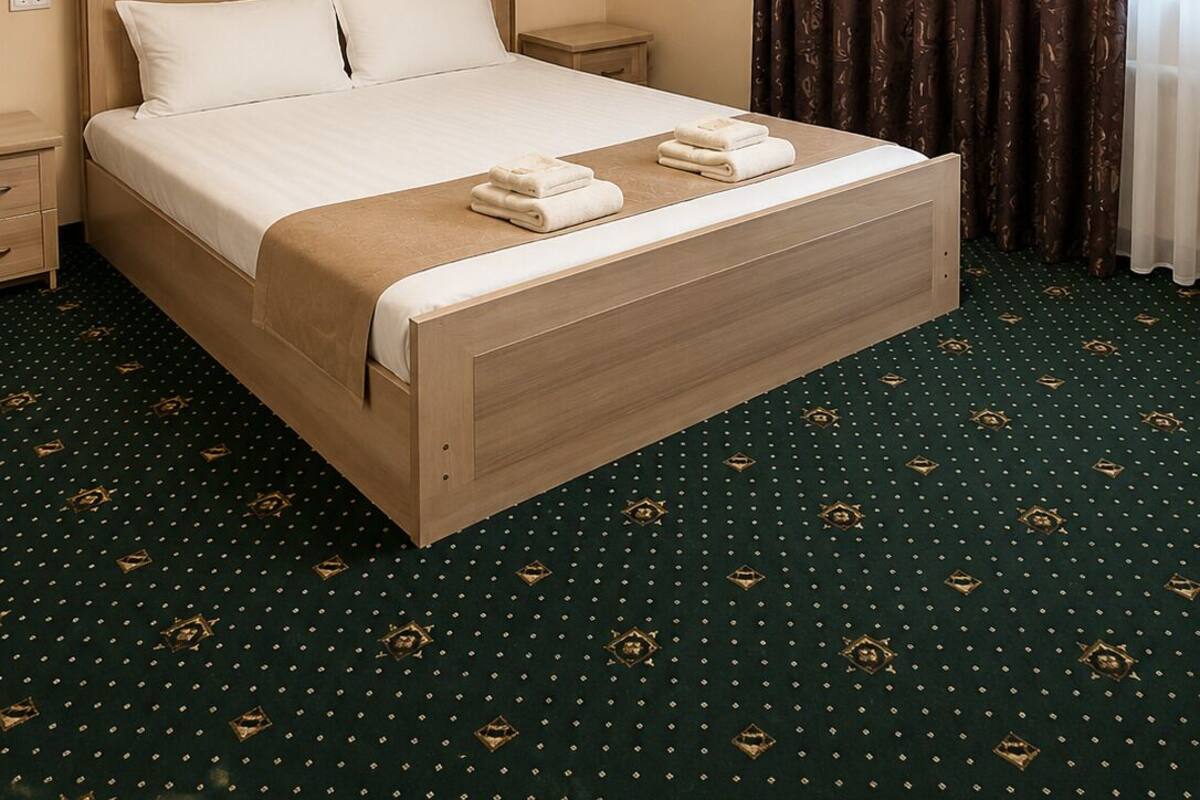Une chambre d’hôtel avec un lit, une table de chevet, une lampe, un tableau au mur et une fenêtre avec des rideaux.
