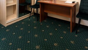 A hotel room with a desk, chairs, a television, a wardrobe, and a patterned carpet. - BOSTON HOTEL (Tashkent)