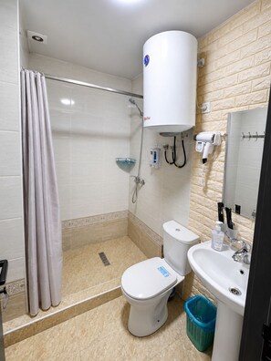Habitación estándar con 2 camas individuales | Baño | Regadera, secadora de cabello, batas, pantuflas 