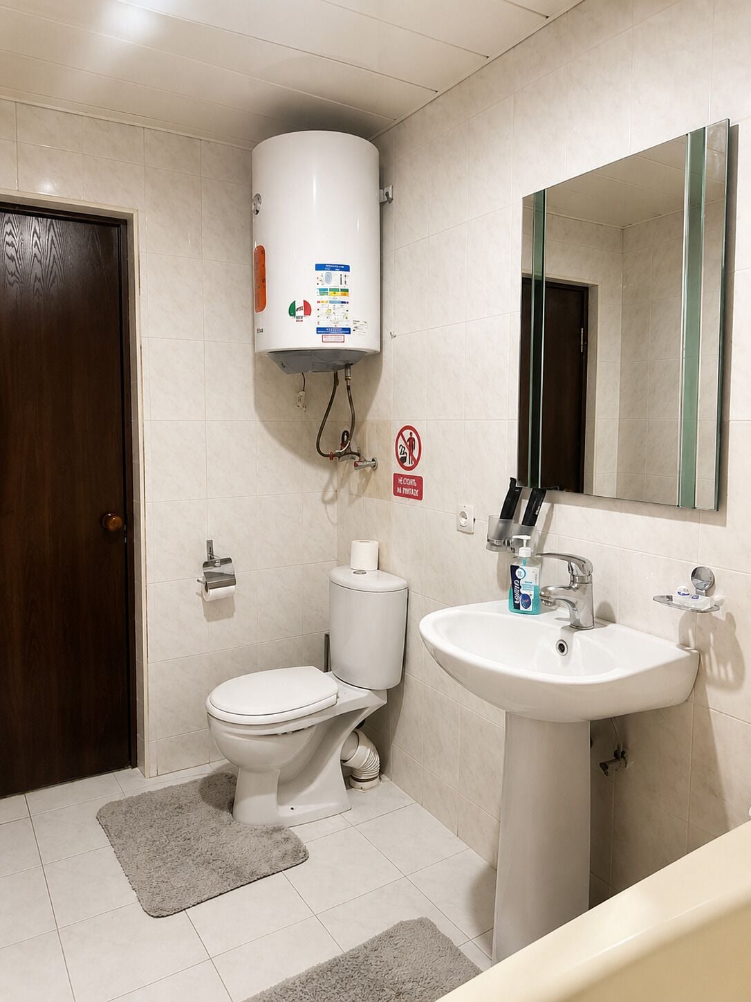 Un baño moderno con inodoro, lavamanos y calentador de agua.