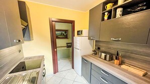 Eine moderne Küche mit grauen Schränken, einer Edelstahl-Spüle und einer Mikrowelle.
