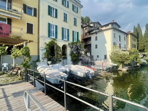 A waterfront property with a dock, covered boats, and buildings with balconies. - Beautiful apartment for 6 guests with WIFI, TV, balcony and pets allowed (San Mamete)