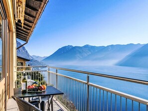 A balcony with a table set with fruit and wine, overlooking a lake with mountains in the background. - Nice apartment for 6 guests with WIFI, TV, balcony and pets allowed (San Mamete)