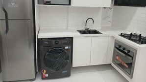A compact kitchen with a stainless steel refrigerator, a dishwasher, a sink, and a built-in oven. - Amazing, stylish 1-bedroom apartment in the heart of Copacabana! (Copacabana Rio de Janeiro)