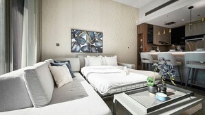 Een moderne hotelkamer met een slaapbank, een bed, een eethoek en een keuken.