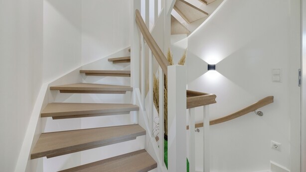 A spiral staircase with wooden steps and a white wall. - "Vacation in vacation home Levi: relaxation and adventure on Sylt!" (Sylt / OT Tinnum)