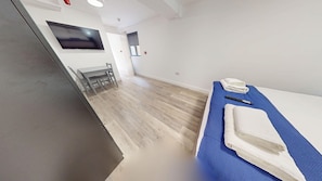 Une chambre d’hôtel avec un lit, un bureau et une chaise.
