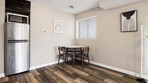A compact kitchen with a built-in refrigerator, a microwave, and a dining area with a round table and chairs. - A Trendy Escape close to Downtown Peoria (Peoria)