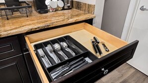 Cozinha com organizador de gaveta contendo utensílios.
