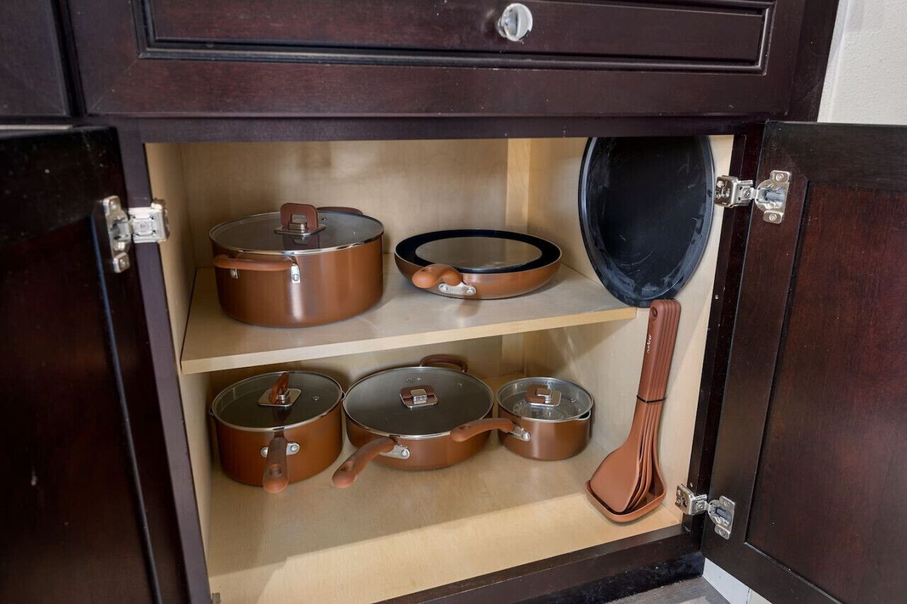 Un meuble en bois doté de trois étagères, chacune contenant différents ustensiles de cuisine.