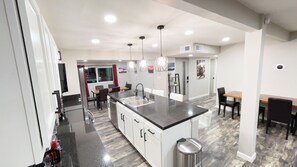 A modern kitchen with a central island, built-in appliances, and pendant lighting. - TheSaguaroSanctuary:FREE*HeatedPool,5BD,3BA,Pool Table,Grill,6 TV's,AC,CottonBedding,Remodeled (Tucson)