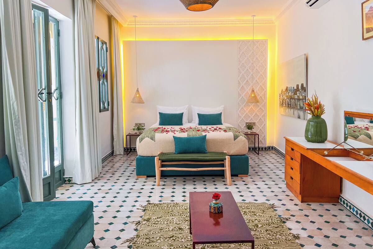 A modern bedroom with a bed, bedside tables, a desk, and a coffee table.