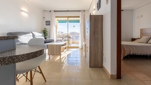 Et moderne hotelværelse med balkon, spiseplads og et separat soveværelse.