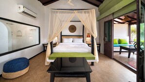 Un dormitorio con cama, mesita de noche, espejo, ventilador de techo y vistas a un área de estar exterior.