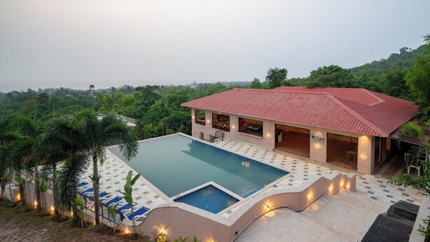 Un hotel con piscina, mobiliario exterior y vistas del paisaje circundante.