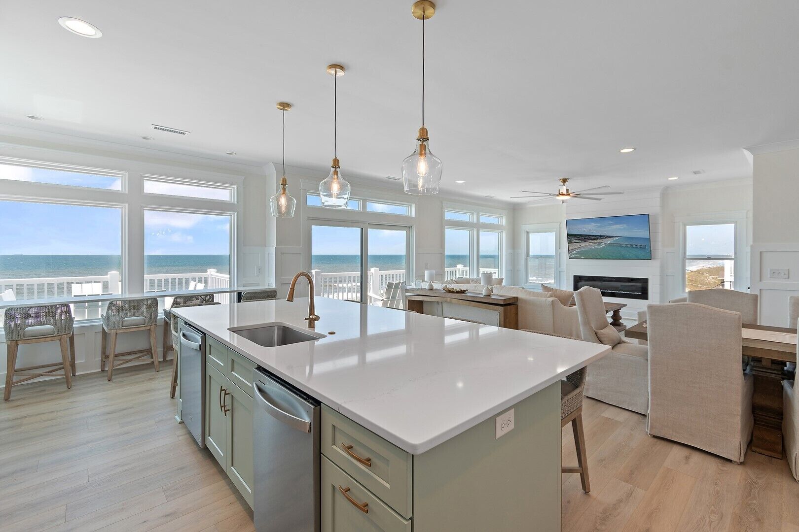 A spacious kitchen with a large island, bar seating, and a view of the ocean.