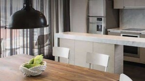 Een moderne keuken met een centraal eiland, roestvrijstalen apparatuur en een ingebouwde wasmachine.