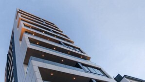 Een modern hooggebouw met meerdere balkons en ramen.