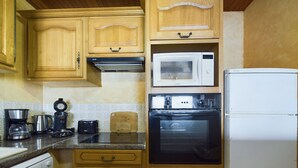 A kitchen with wooden cabinets, a microwave, a toaster, a coffee maker, and a dishwasher.