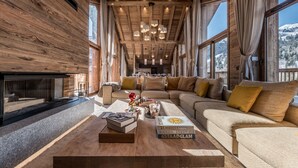 A spacious living room with a large sofa, a coffee table, and a fireplace. - Luxury penthouse with terrace, sauna, and hot tub, 5 bedrooms (Les Allues)