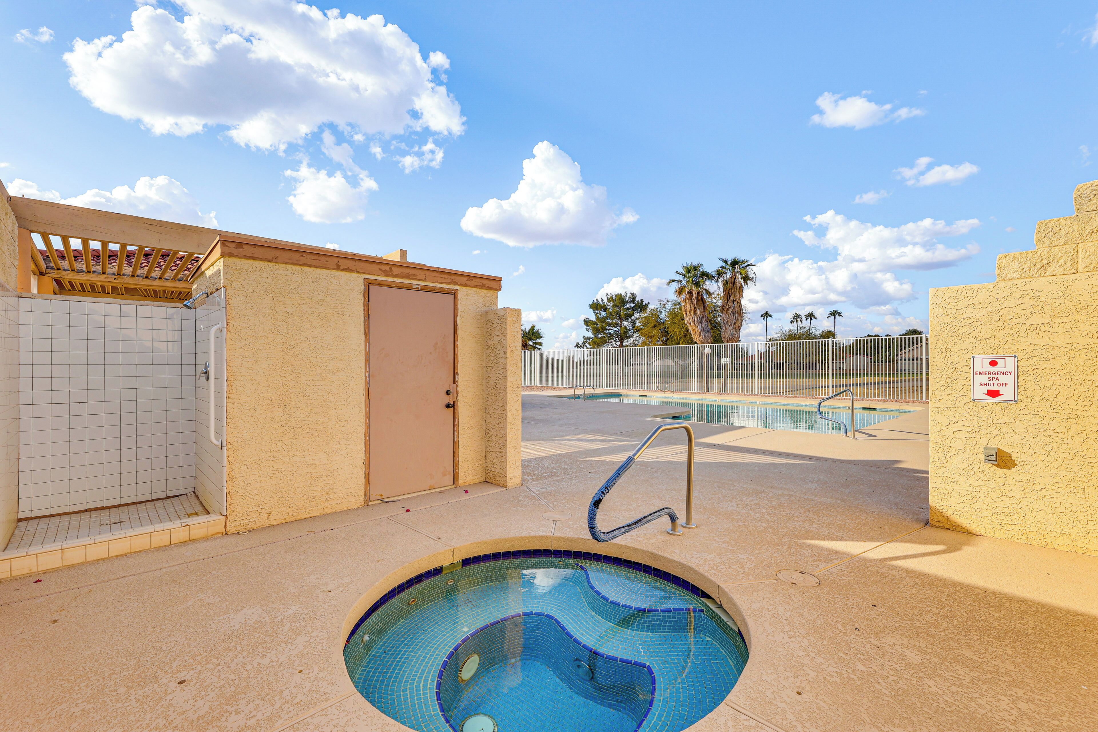 A pool area with a tiled deck, a small pool, and a covered shower area.