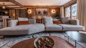 A modern living room with a sectional sofa, a dining area, and a Christmas tree. - Luxury apartment, 3 bedrooms, fireplace, concierge 5*, ski room, non-smoking (Les Allues)