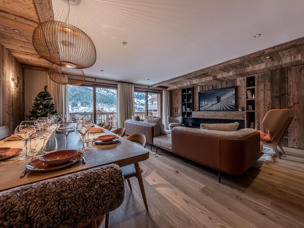 Relax in this stylish living space with a dining table for meals, a comfortable sofa, and a large window offering a view of the outdoors.