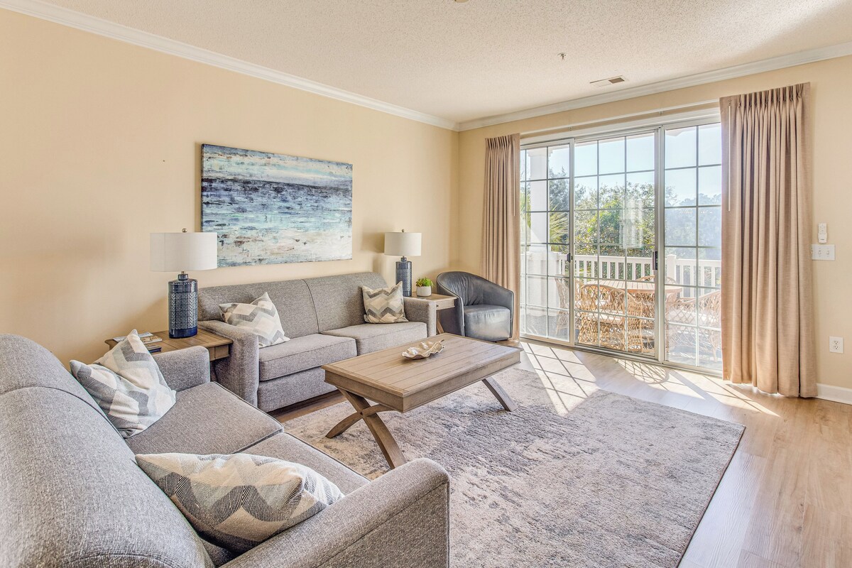 Un salon comprenant un canapé, une table basse et un tableau accroché au mur.