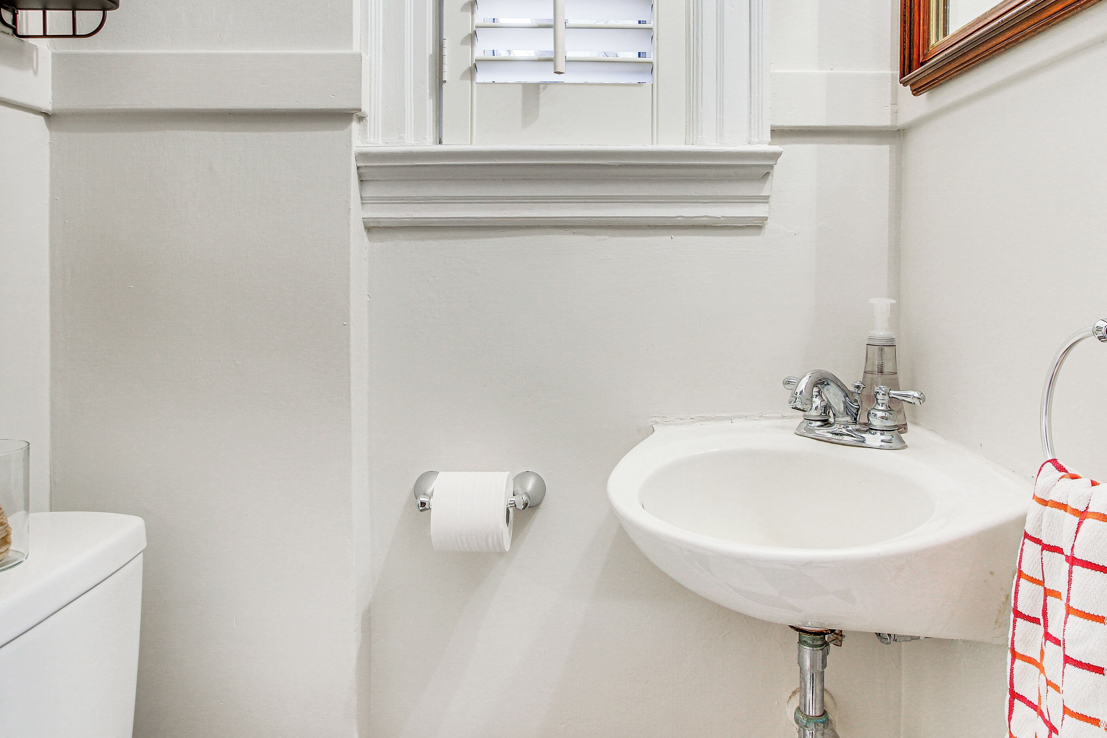 A bathroom with a toilet, sink, and towel rack.