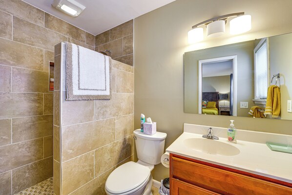 Une salle de bain avec des toilettes, un lavabo et un miroir.