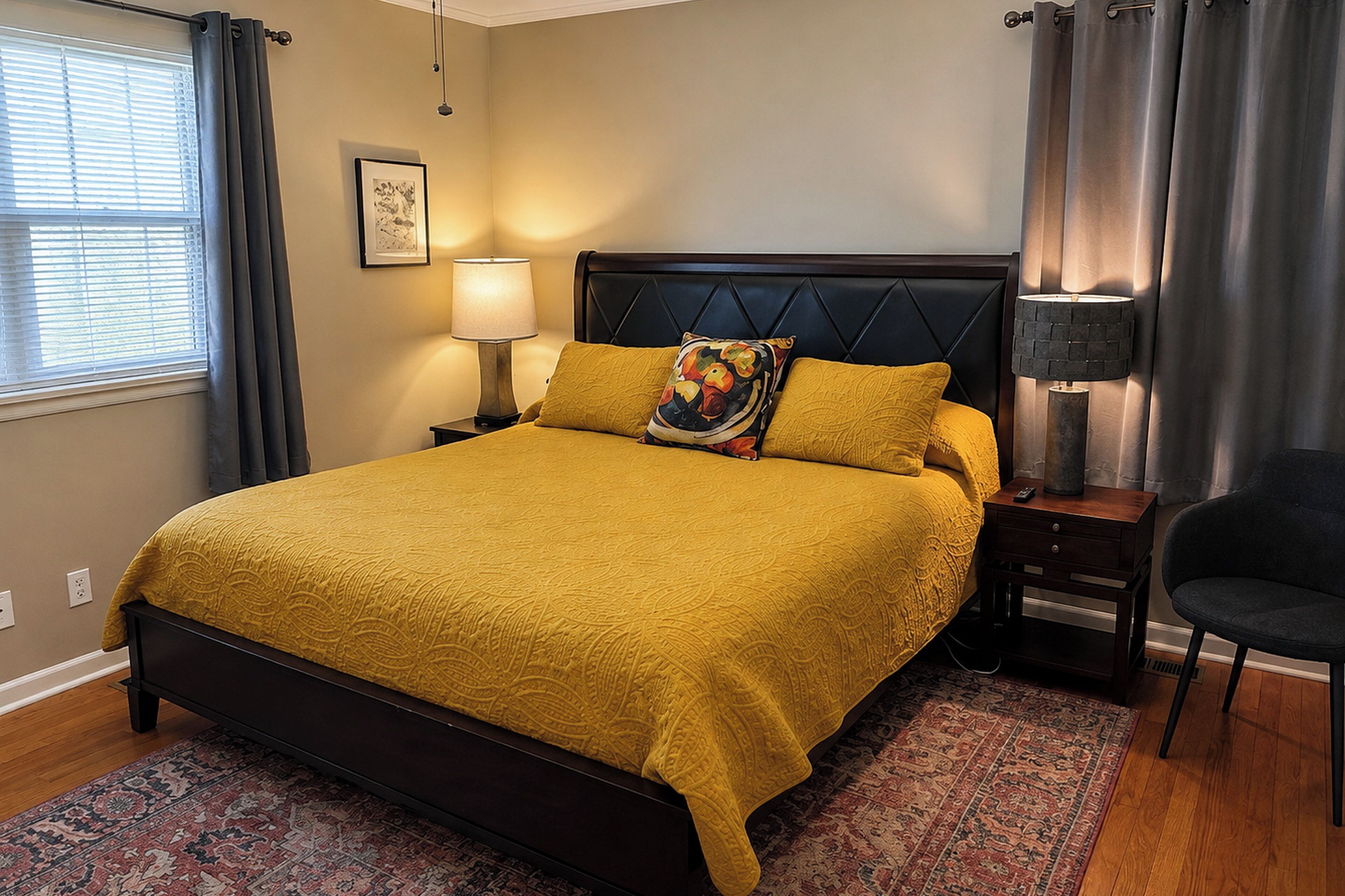 Una habitación de hotel con cama, mesita de noche, lámpara, sillón y ventana con cortinas.
