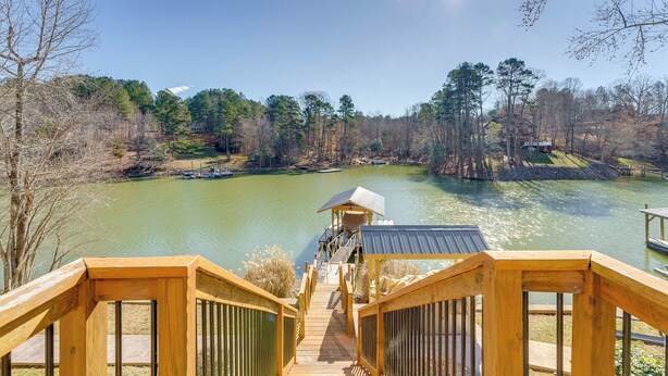 A wooden staircase leading to a dock over a calm lake, surrounded by trees and a clear sky. - Game Room! Boater's Base on Lookout Shoals Lake (Stony Point)