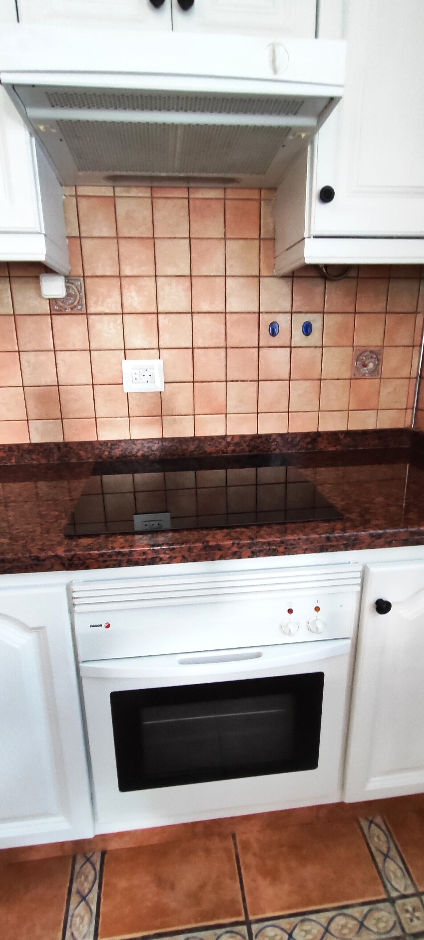 A kitchen with a stove, oven, and tiled backsplash.
