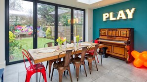 Un comedor con un piano y un letrero que dice 'PLAY' en la pared.