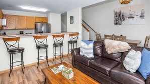 Een modern appartement met keuken, eethoek en woonkamer.