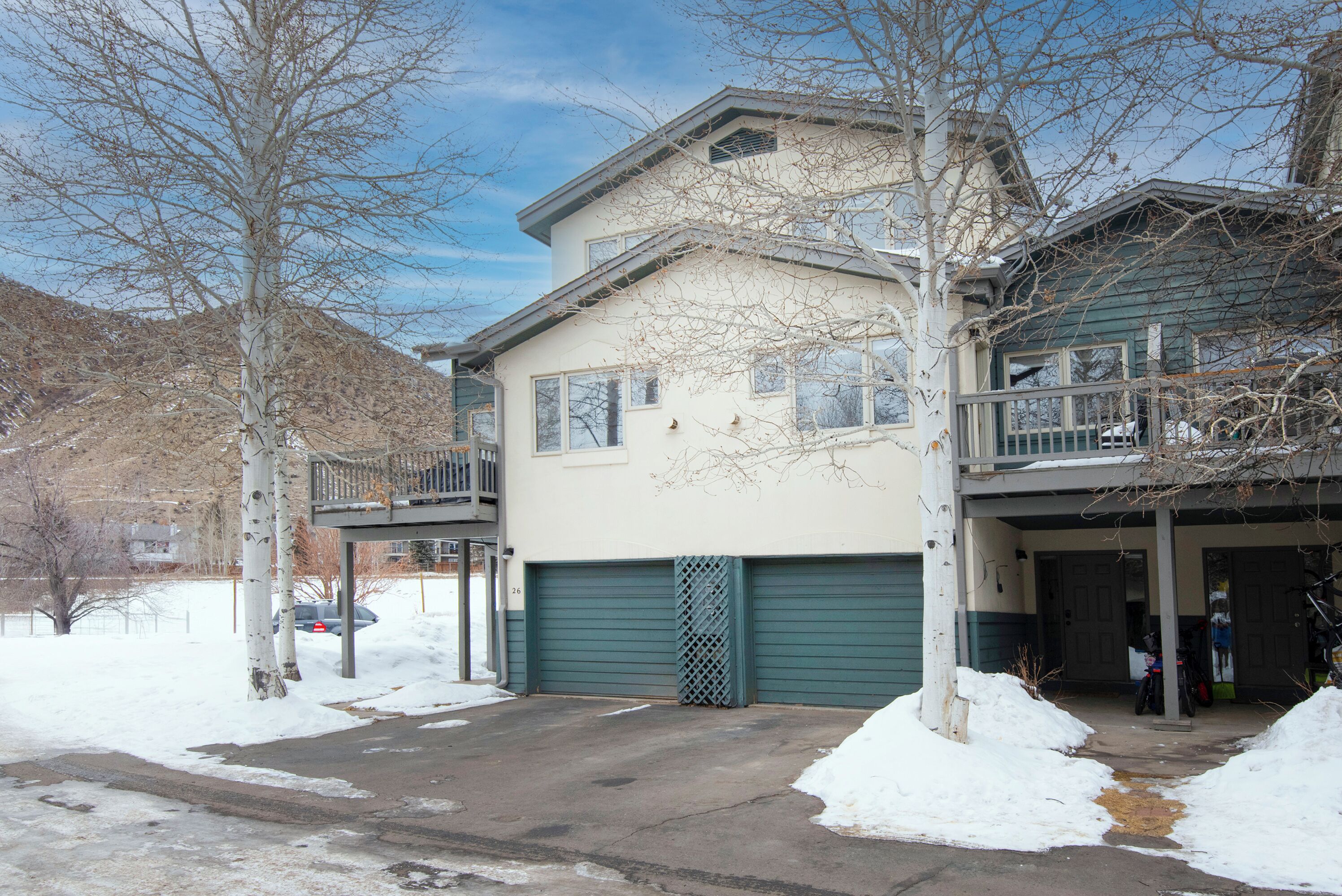 A two-story house with a garage, a balcony, and a driveway.