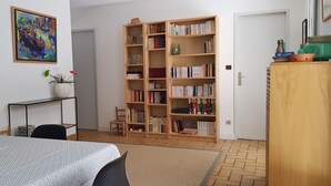 A room with a dining table, chairs, a bookshelf, and a painting on the wall. - Landes house between beach and lake in SOORTS HOSSEGOR, ideal for families (Soorts-Hossegor)