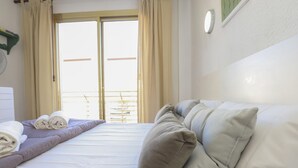 Une chambre d’hôtel avec un lit, des oreillers, une table de chevet et une fenêtre avec des rideaux.