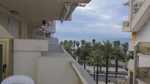 Un balcon avec vue sur la mer et les palmiers.