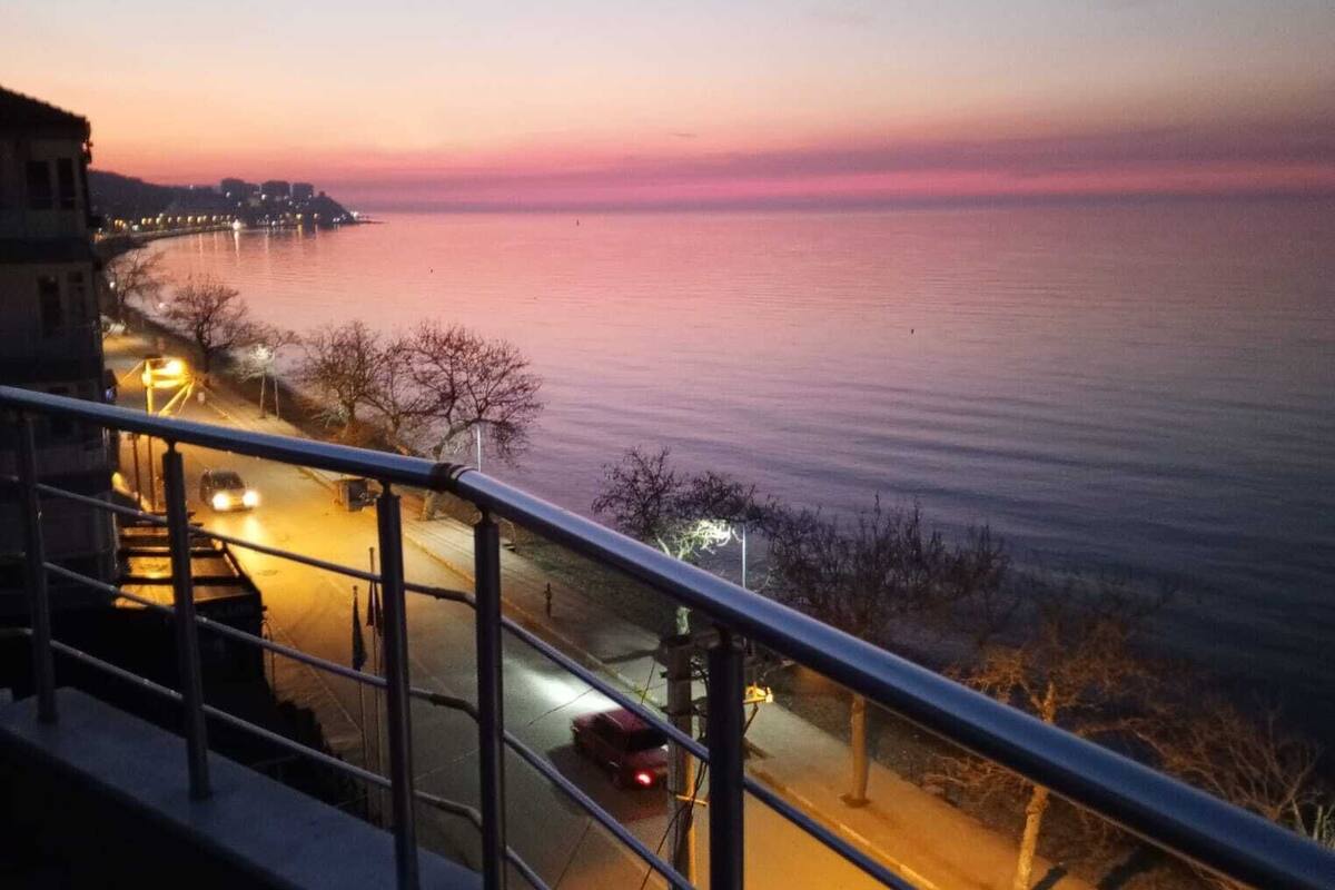 Un balcon donnant sur une mer calme, au crépuscule.