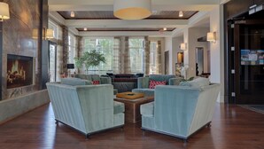 A spacious lobby with a high ceiling, wooden beams, and a large chandelier. There are comfortable seating areas with sofas and a coffee table. - Kids Love Hidden Bunk Room - Seasons at Sandpoint (Sandpoint)