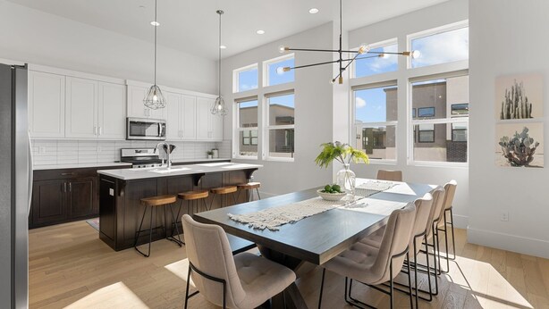 A modern kitchen with white cabinets, a central island, and pendant lighting. - Villa #20 At Bloomington Country Club 3 Bedroom Condo (St. George)