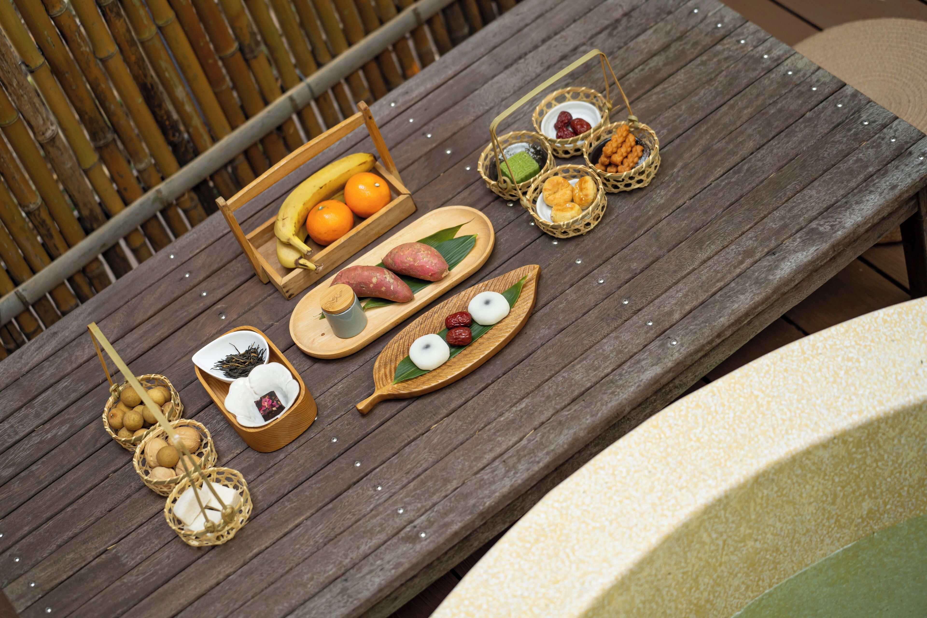 A wooden table with various food items and baskets.