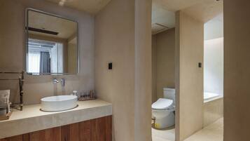 Un baño moderno con tocador de madera, un espejo grande y un inodoro.