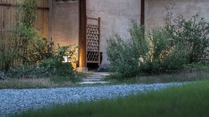 A traditional building with a thatched roof and stone walls, a wooden door, and a window. - Hegu Villa Hotel (Changzhou)