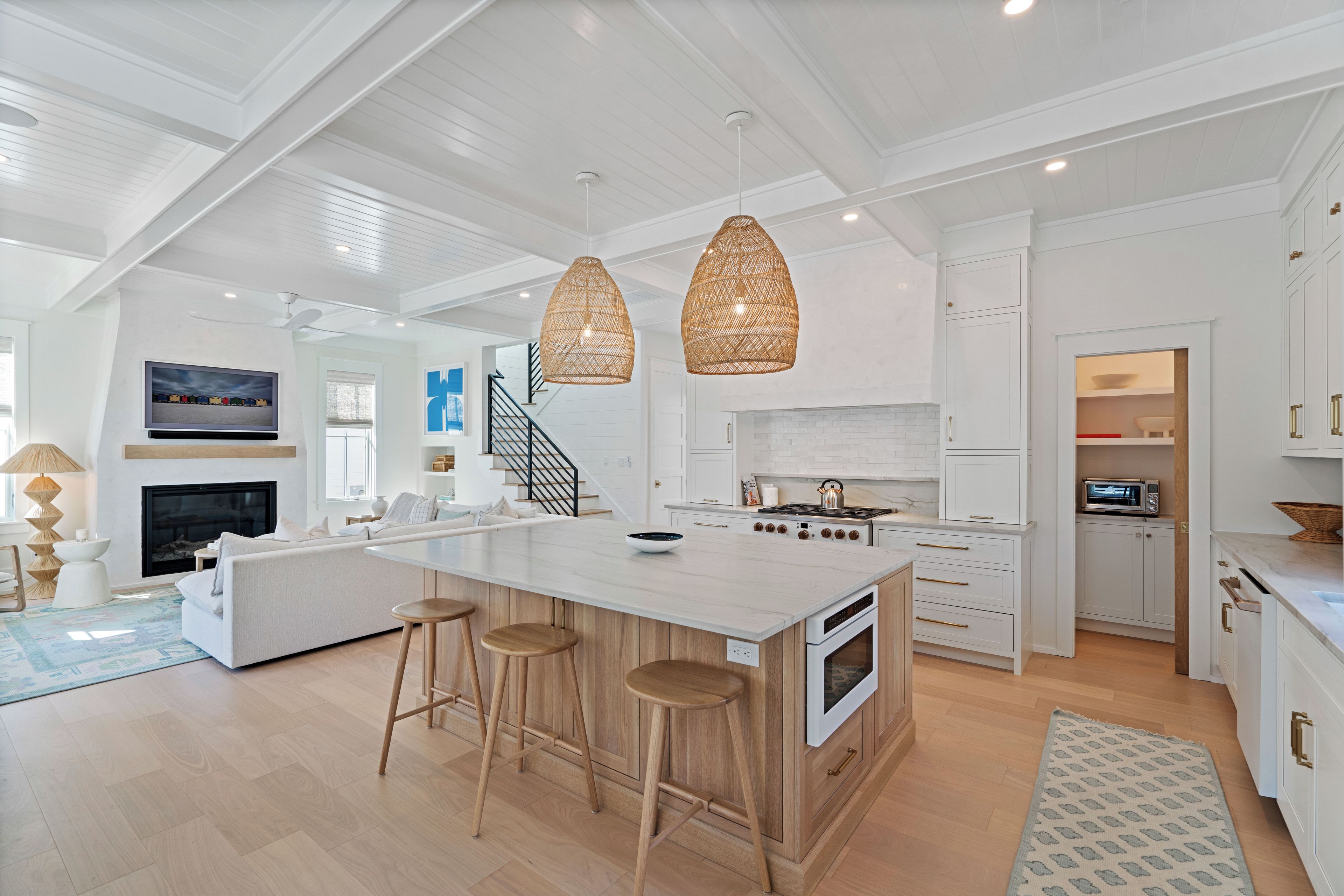A spacious kitchen with a large island, white cabinetry, and a modern design.