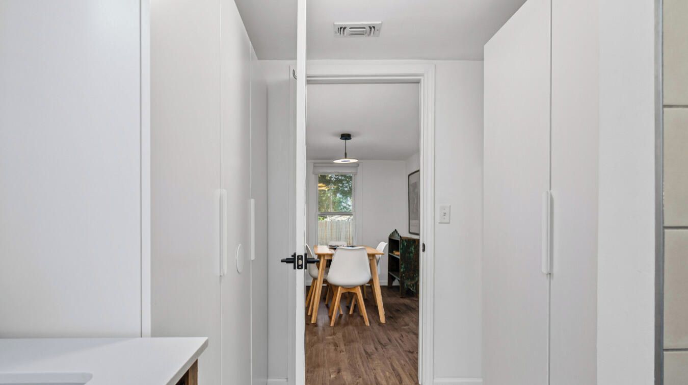 A hallway leading to a dining area with a table and chairs.