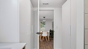 Un couloir menant à une salle à manger équipée d’une table et de chaises.