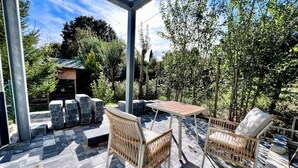 An outdoor patio with stone flooring, a table, and wicker chairs.